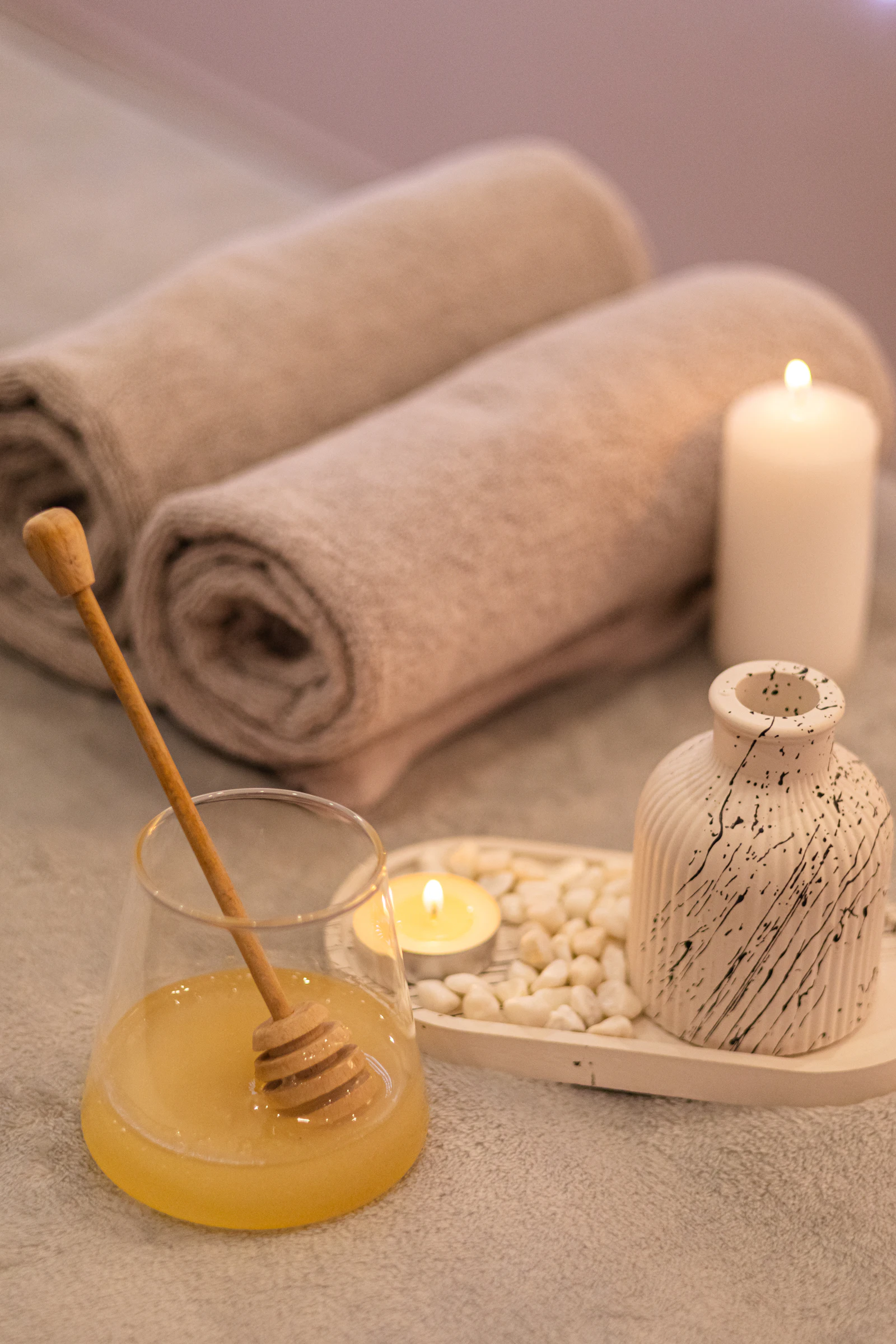 Свёрнутые полотенца и свеча — детали wellness-пространства
